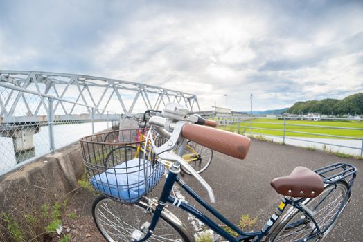 A close up fisheye shot of a bicycle with a bridge in the background.