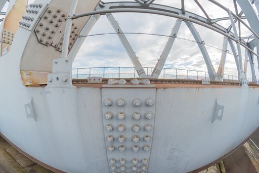 A close up fisheye shot of nuts and bolts on a bridge.