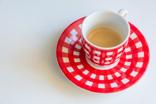 Red striped cup of coffee on a white table