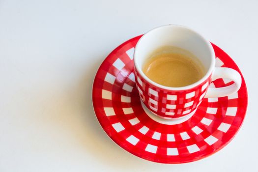 Red striped cup of coffee on a white table