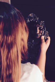 a girl staring at the mirror but her reflection is horrifying.