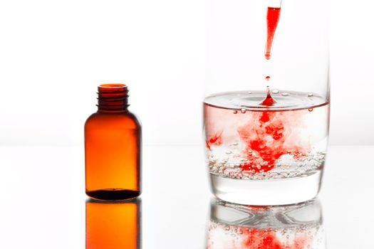 Medicine dropping with a pipette into a glass of water