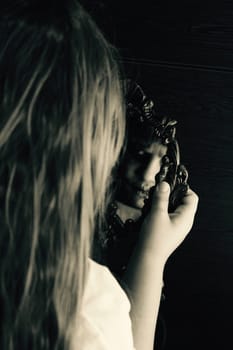 a girl staring at the mirror but her reflection is horrifying.