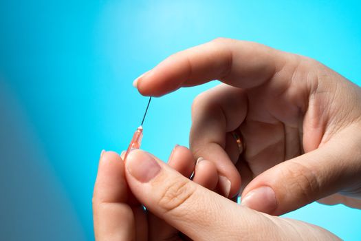 Blood test is taken at the finger, against a blue background