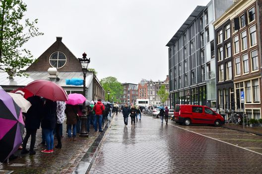 Amsterdam, Netherlands - May 16, 2015: People queuing at the Anne Frank house and holocaust museum in Amsterdam, Netherlands, on May 16, 2015. Anne Frank house is a popular tourist destination.