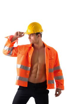 Handsome young construction worker with orange suit open on naked torso, wearing yellow hardhat