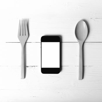 spoon and smart phone concept eating social over table background black and white tone color style