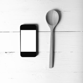 spoon and smart phone concept eating social over table background black and white tone color style