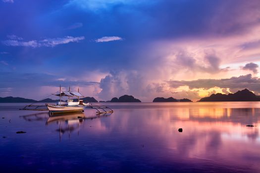 Tropical sunset with a banca boat in Palawan - Philippines