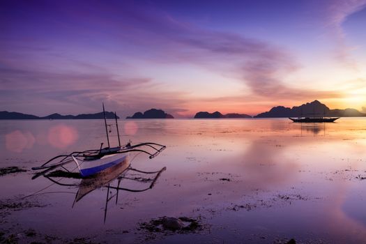 Tropical sunset with a banca boat in Palawan - Philippines