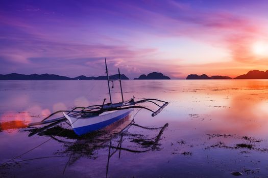 Tropical sunset with a banca boat in Palawan - Philippines