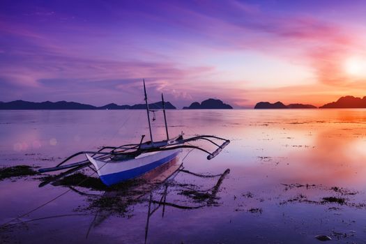 Tropical sunset with a banca boat in Palawan - Philippines