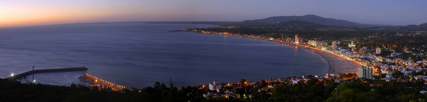 Summer beach panoramic cityscape with clear sunset and seashore aerial view. Piriapolis, Uruguay.