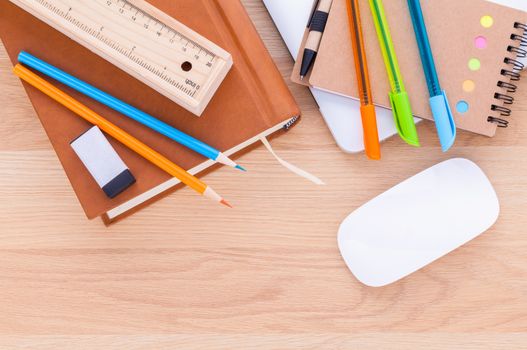 Back to school concept with school supplies laptop ,book, pen,mouse,and colored pencil on wooden table .