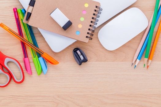 Back to school concept with school supplies laptop ,notebook, pen,mouse,and colored pencil on wooden table .