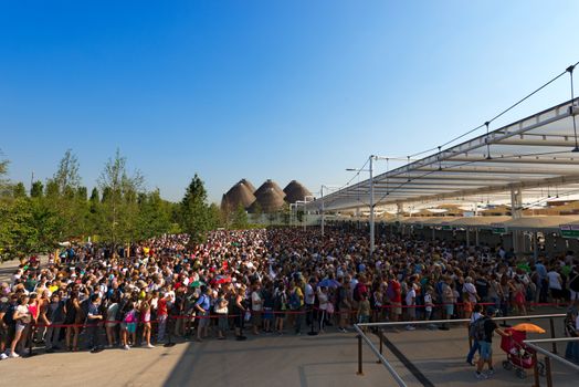 MILAN, ITALY - AUGUST 31, 2015: Long queue of visitors waiting in the morning at entrance of Expo Milano 2015, universal exposition on the theme of food, in Milan, Lombardy, Italy, Europe