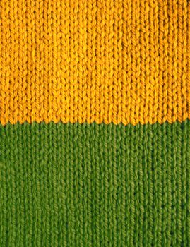 Stocking stitch knitting in yellow and green stripes as an abstract background texture