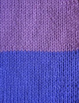 Purple and blue striped stockinette knitting as an abstract background texture