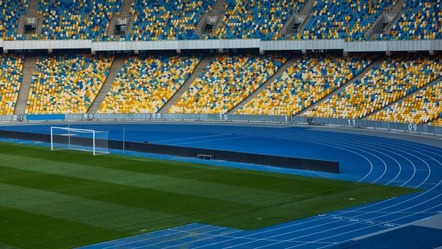 Huge Empty Football Arena, seats are painted a yellow and a blue