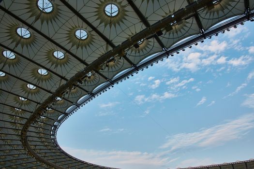 Look over stadium roof with cloudy blue sky