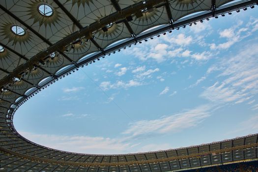 Look over stadium roof with cloudy blue sky