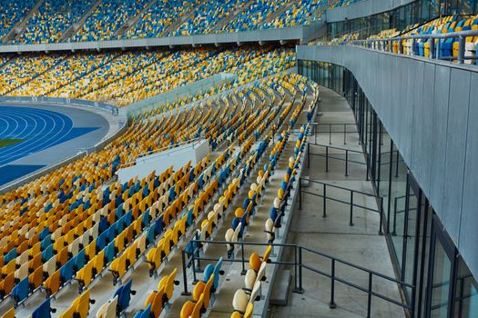 Huge Empty Football Arena, seats are painted a yellow and a blue