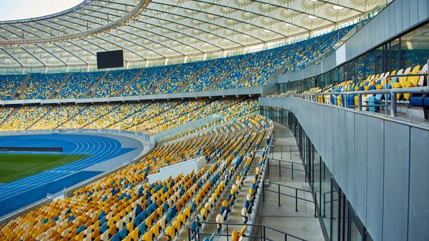 Huge Empty Football Arena, seats are painted a yellow and a blue