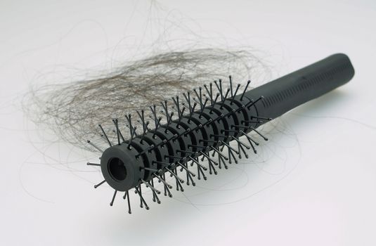 Long hair falling attack with black comb on white background.                               