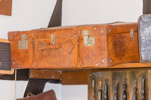 Very old used travel suitcase with scuffs.