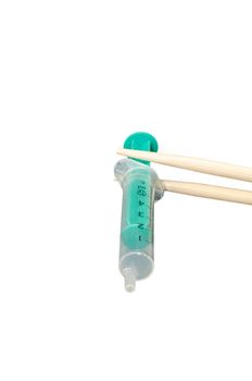  Chopsticks with syringe. Symbolic Chinese medicine, alternative medicine - homeopathy.