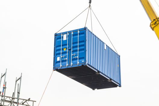 Blue building containers, cargo containers, residential containers at a loading crane.