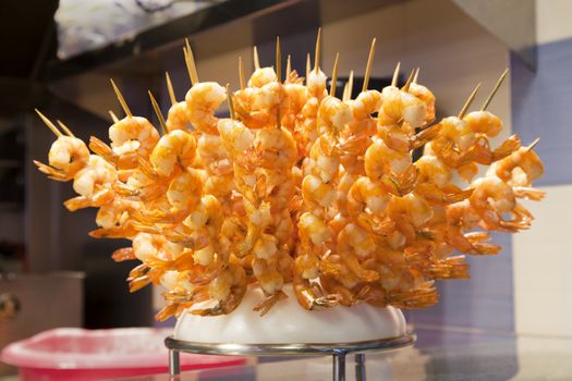 Bunch of grilled prawns on a stick in a street market