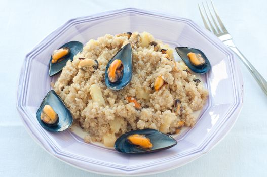 Warm quinoa salad with mussels, tomatoes and potatoes