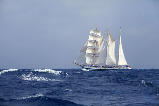 Barquentine with white sails in the calm sea