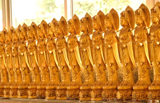 Capturing the line of brass goddess of mercy statues in Chinese tample which it is captured in southen of Thailand