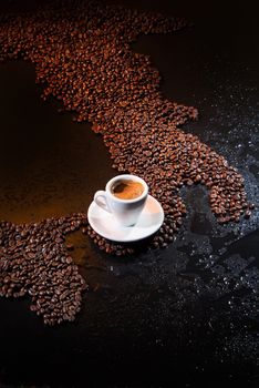 White cup of coffee standing on coffee beans