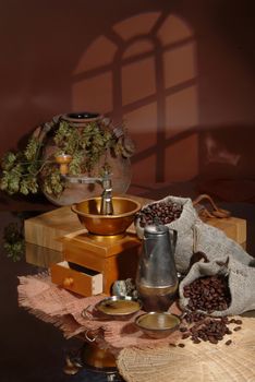 Coffee beans, mill, and ceramic pot ona studio background