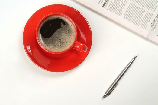 Cup of coffee, pen and newspaper on isolated studio background