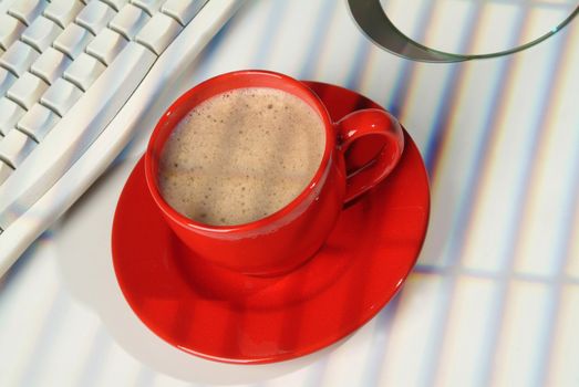 Cup of coffee and a part of computer keyboard