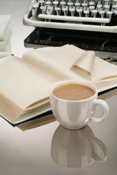 Cup of coffee an old typewriter on a glass background