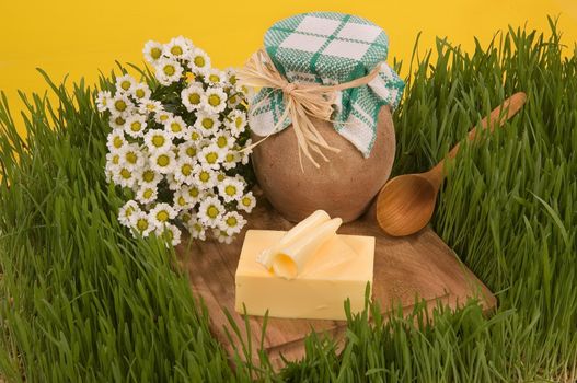 Earhware, grass, butter and wooden spoon