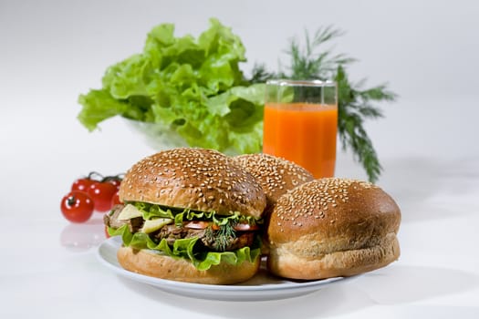 Hamburgers, greenery, tomatoes and juice