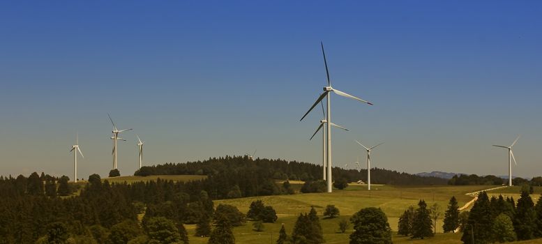 Several wind turbines in a landscape of mountains