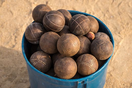 In the picture a basket full of used balls to play ballgame( Bocce,Pentanque) on the beach.