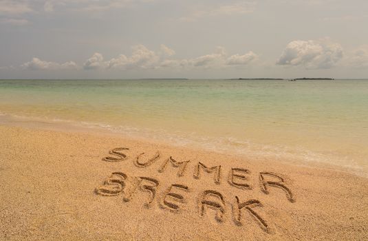 In the photo a beach in Zanzibar in the afternoon where there is an inscription on the sand "Summer Break".