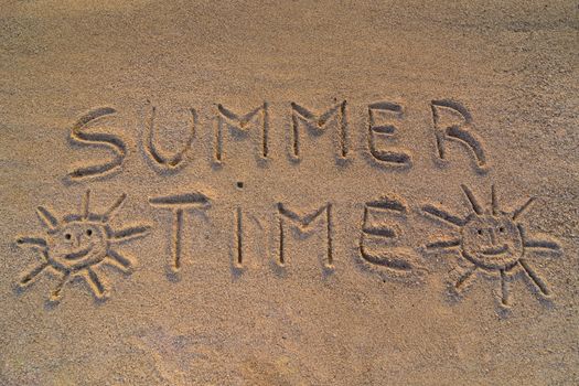In the picture the words on the sand "Summer time"