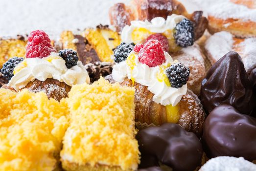 In the pictured typical italian pastries with cream,choccolate,rasperry and blackberry with various forms.