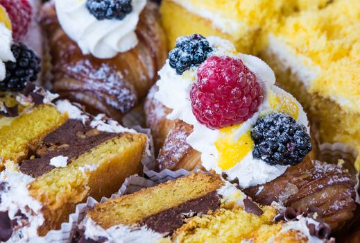 In the pictured typical italian pastries with cream,choccolate,rasperry and blackberry with various forms.