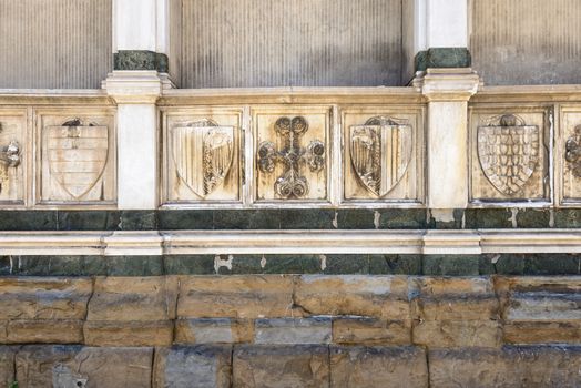 In the picture a close up the wall of Santa Maria Novelle in Florence , where we see symbols of Christianity and the medieval noble families .