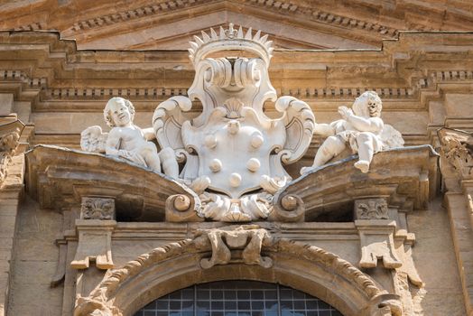 In the picture a marble statue of the Middle Ages showing two angels, in the historic center of Florence.